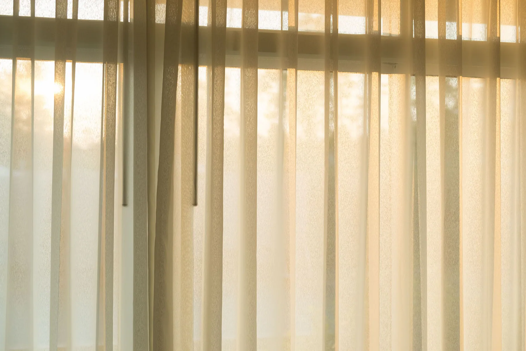 Sheer curtains filtering daylight in a home